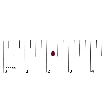 White metal earring with a pear-shaped red gemstone in a 3-prong setting shown on a scale with inch markings, front angle.