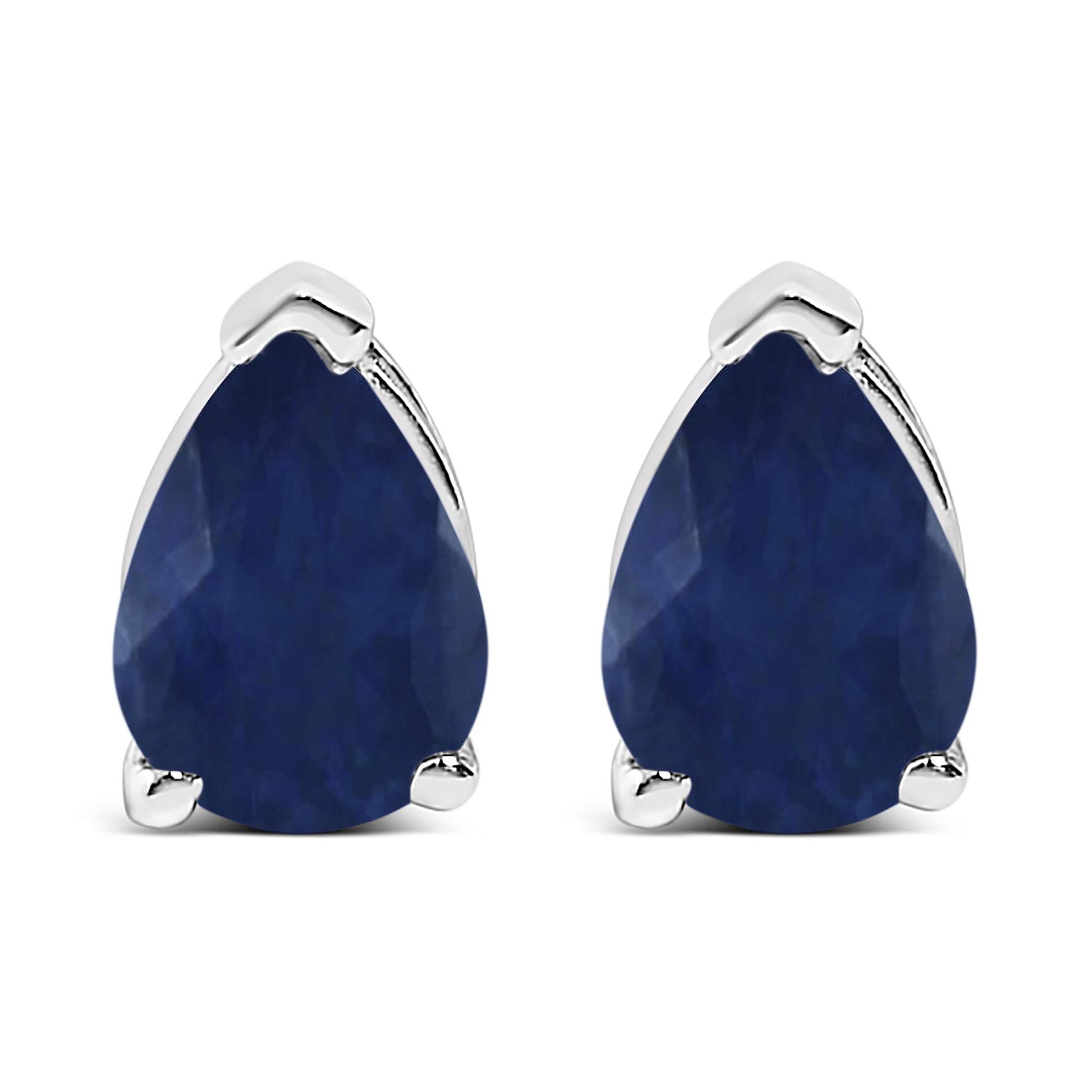 Front view of white metal earrings with pear-shaped blue gemstones in three-prong settings.