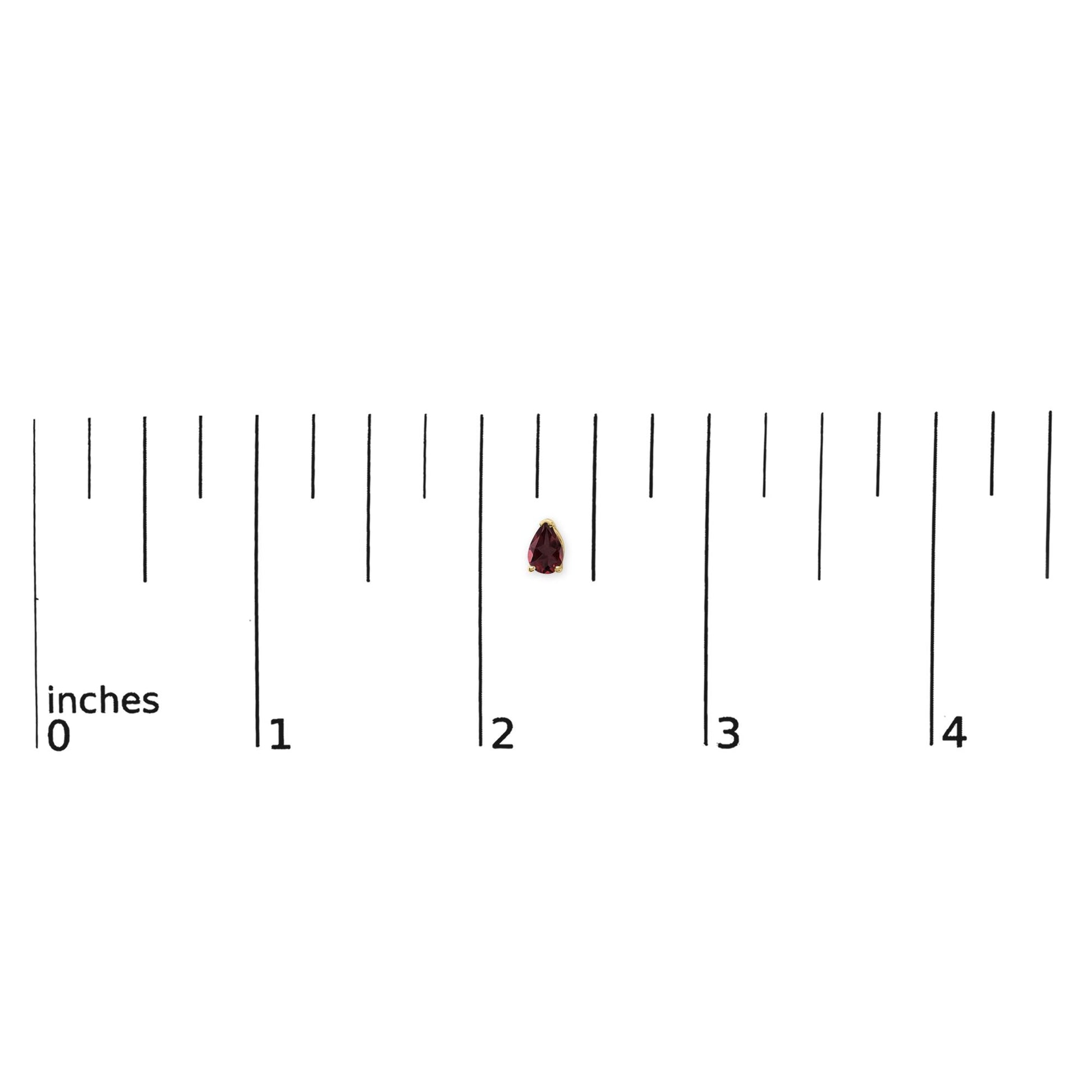 Yellow metal pear-shaped red gemstone stud earring shown on a scale, front view.