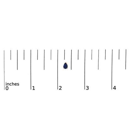 Yellow metal pear-shaped blue gemstone earring shown on a ruler scale from a top front angle.