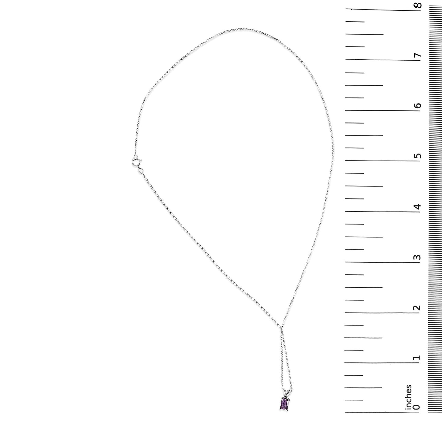 White metal necklace with a white metal chain holding a small emerald-cut purple gemstone pendant in a four-prong setting, shown laid flat next to a ruler for scale.