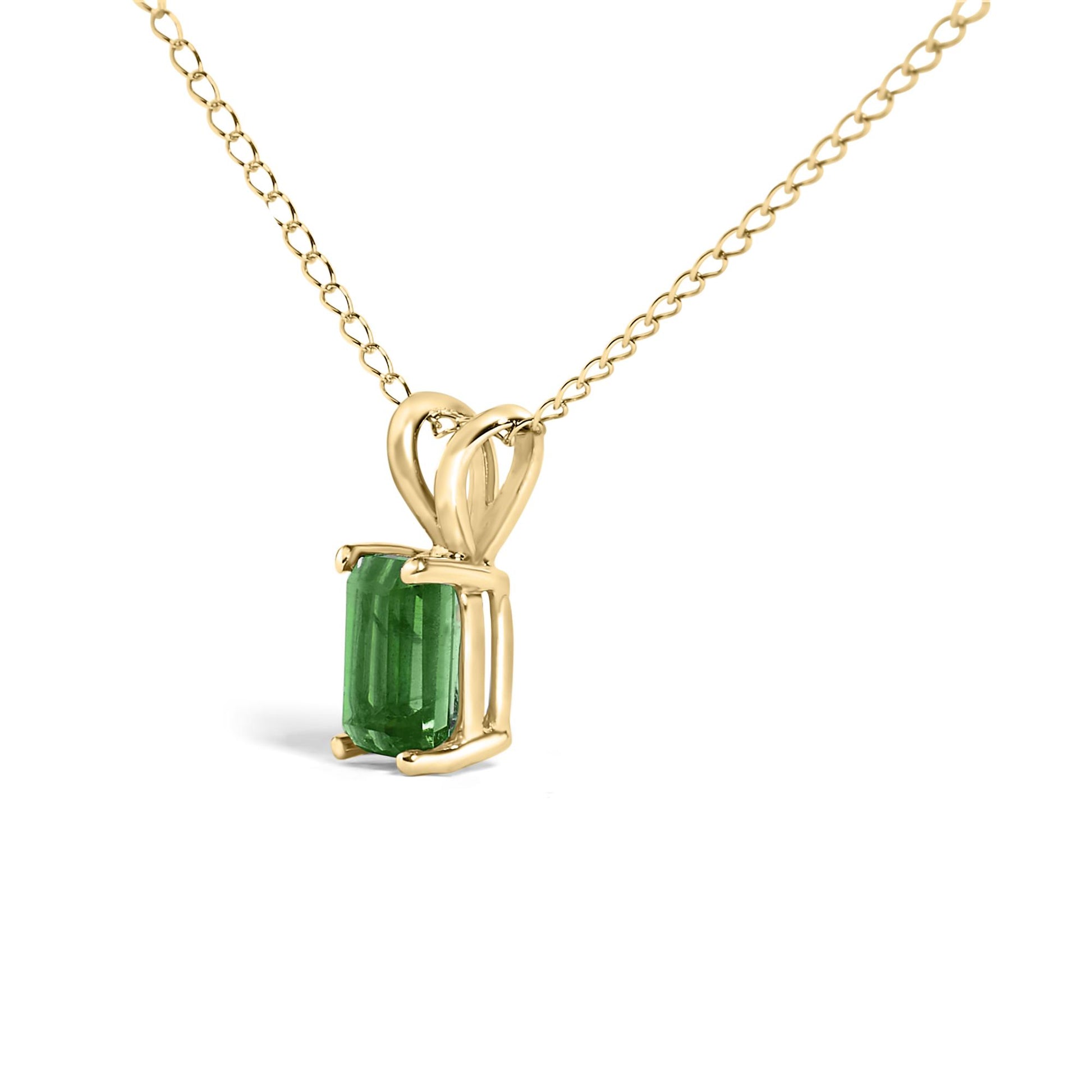 Yellow metal necklace shown in a close-up front angle with a single green rectangular gemstone in a four-prong setting.