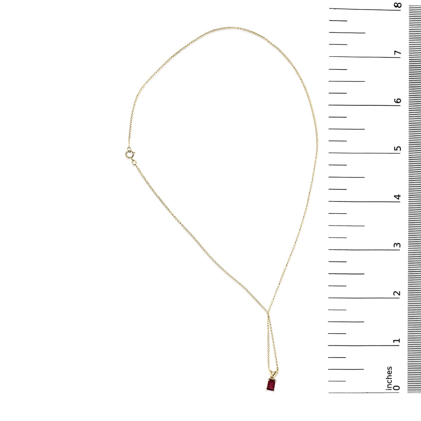 Yellow necklace with a small red rectangular gemstone pendant in a 4-prong setting, shown flat on a white surface next to a ruler for scale, top-down view.