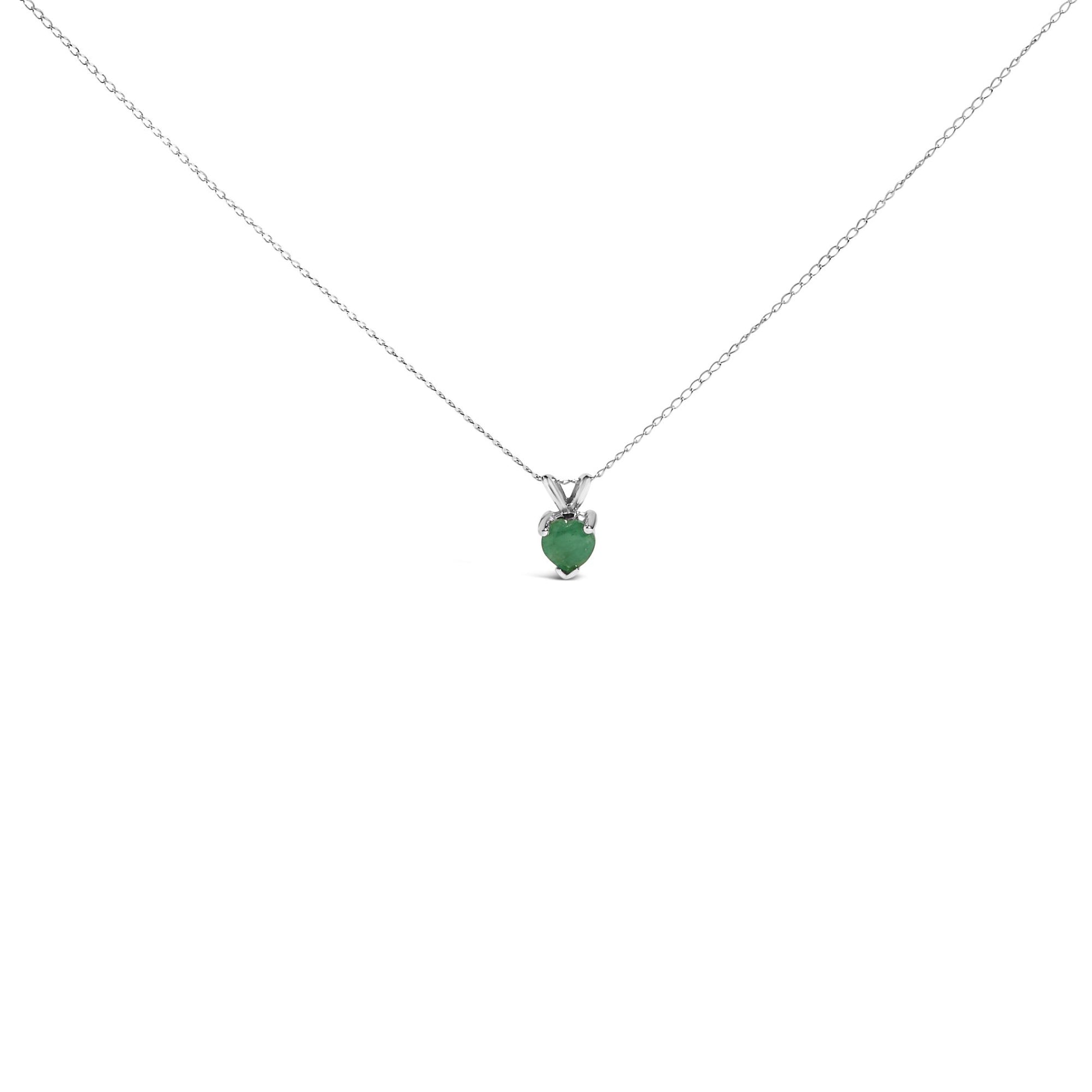 Close-up front angle of a white metal necklace with a heart-shaped green gemstone pendant set in a three-prong setting.