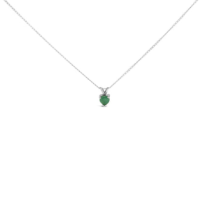 Close-up front angle of a white metal necklace with a heart-shaped green gemstone pendant set in a three-prong setting.