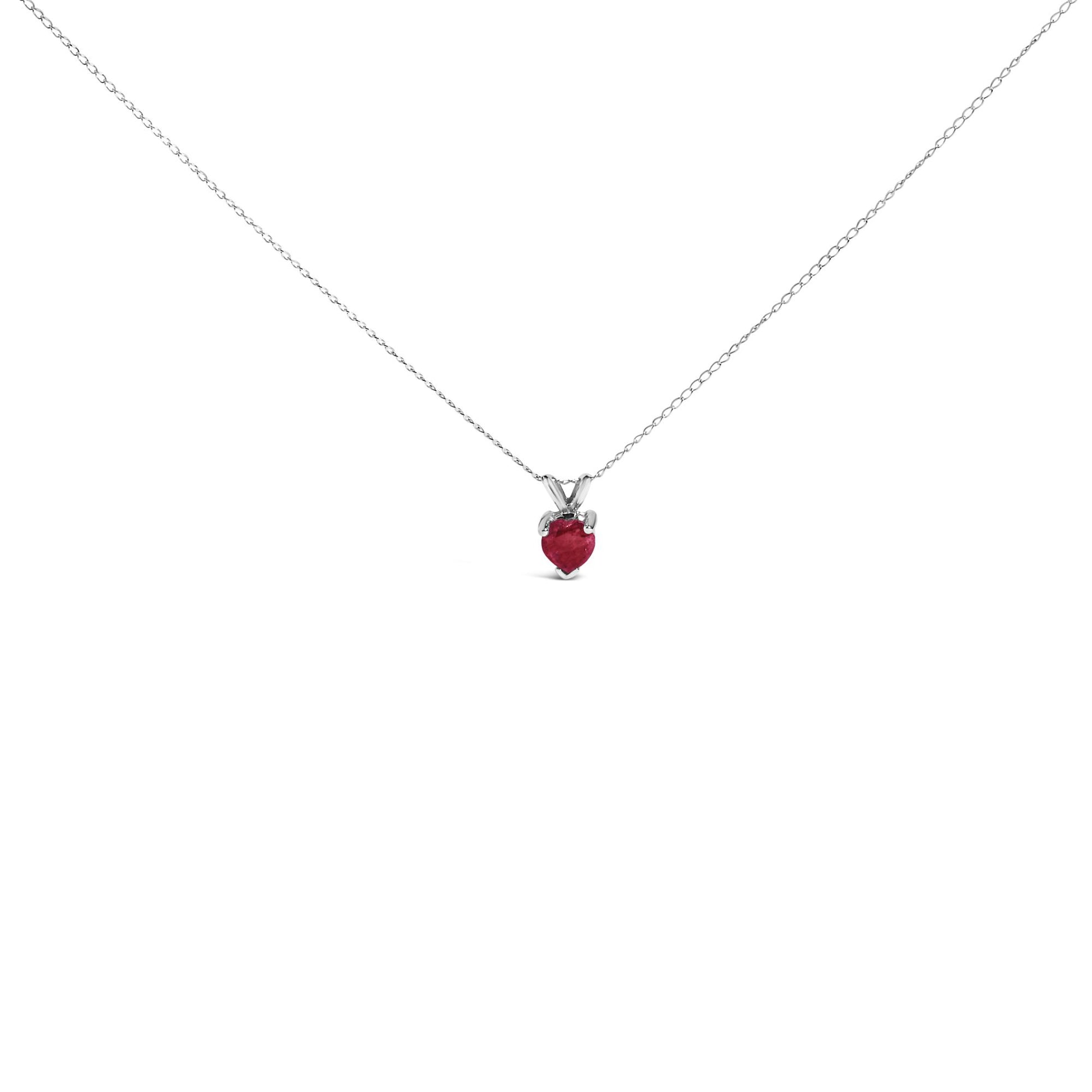 White metal necklace with a heart-shaped red gemstone pendant in a three-prong setting, shown in a front-facing close-up.