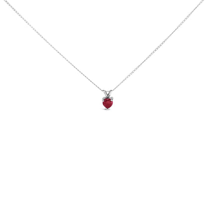 White metal necklace with a heart-shaped red gemstone pendant in a three-prong setting, shown in a front-facing close-up.
