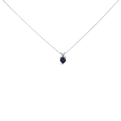 White necklace with a heart-shaped blue gemstone pendant in 3-prong setting, shown from the front on a white background.