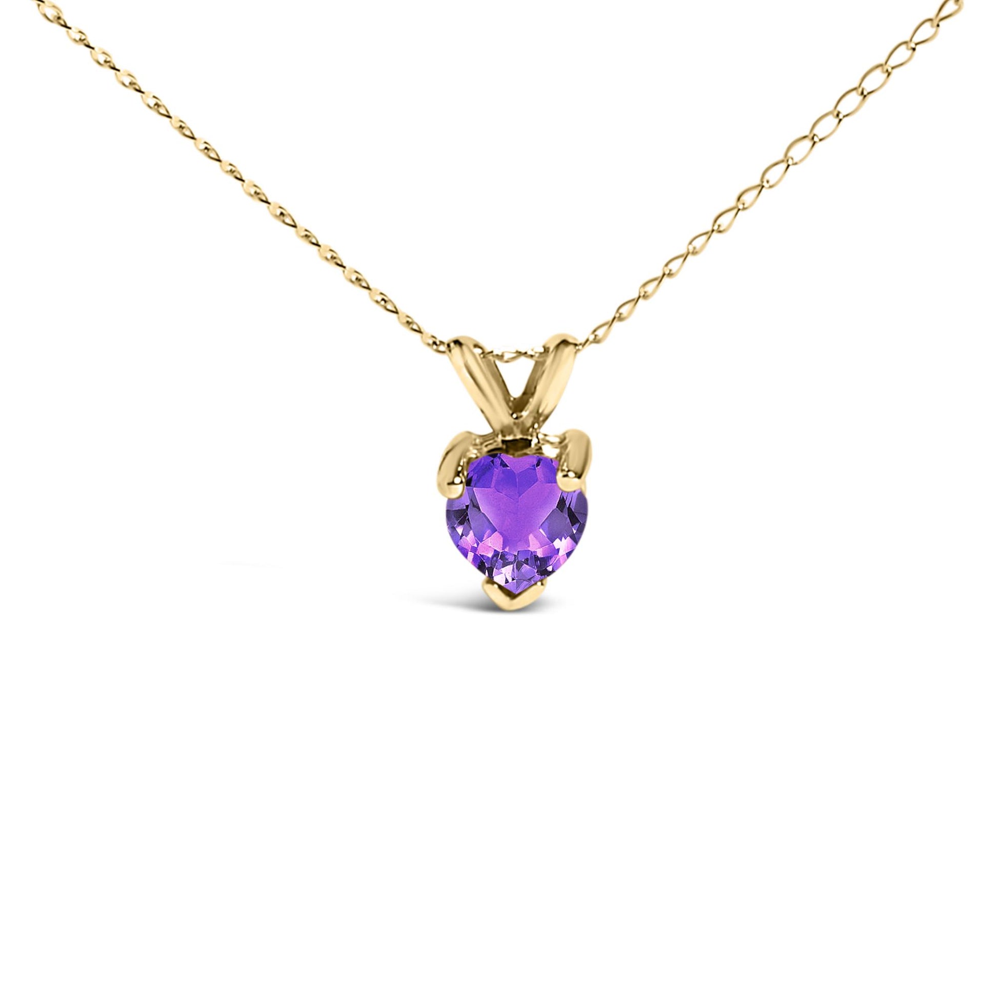 Close-up front angle of a yellow metal necklace with a heart-shaped purple gemstone pendant in a three-prong setting.