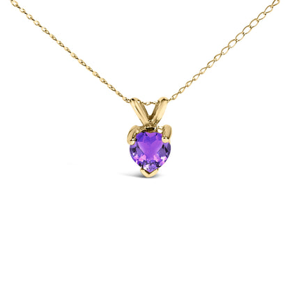Close-up front angle of a yellow metal necklace with a heart-shaped purple gemstone pendant in a three-prong setting.