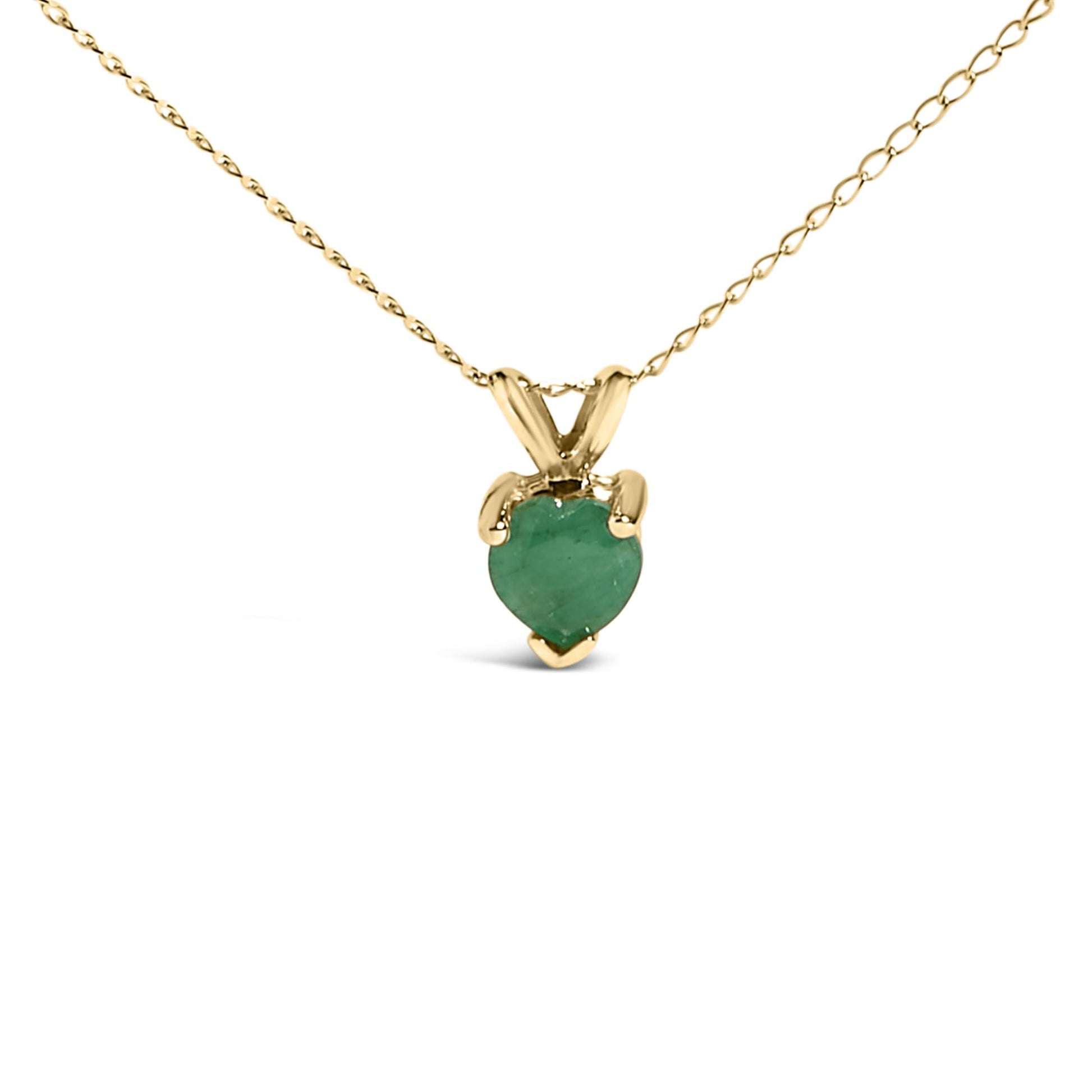 Close-up front view of a yellow metal necklace with a heart-shaped green gemstone pendant in a three-prong setting on a white background.