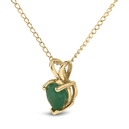 Close-up front angle of a yellow metal necklace with a heart-shaped green gemstone pendant in a three-prong setting.