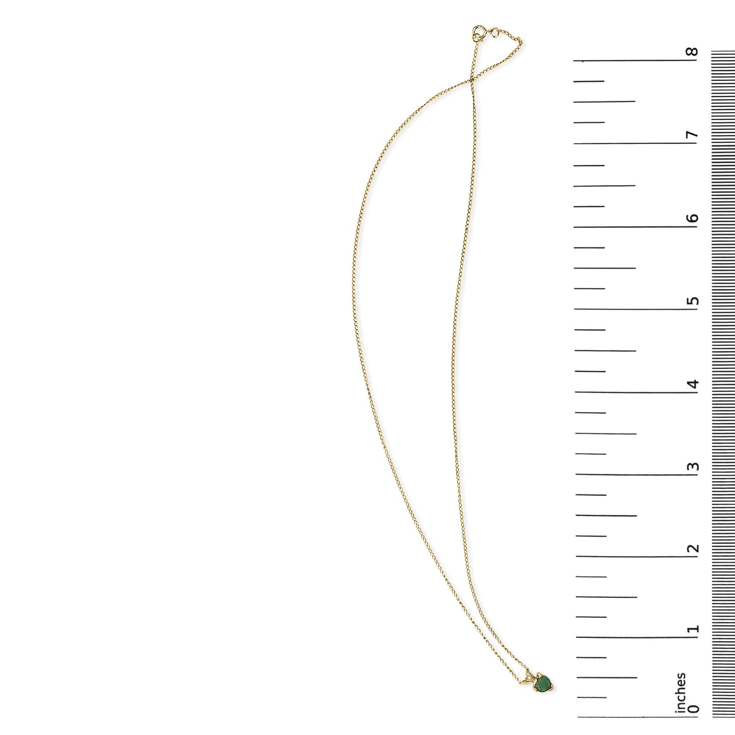 Yellow necklace with a small heart-shaped green gemstone pendant, shown on a scale from above.