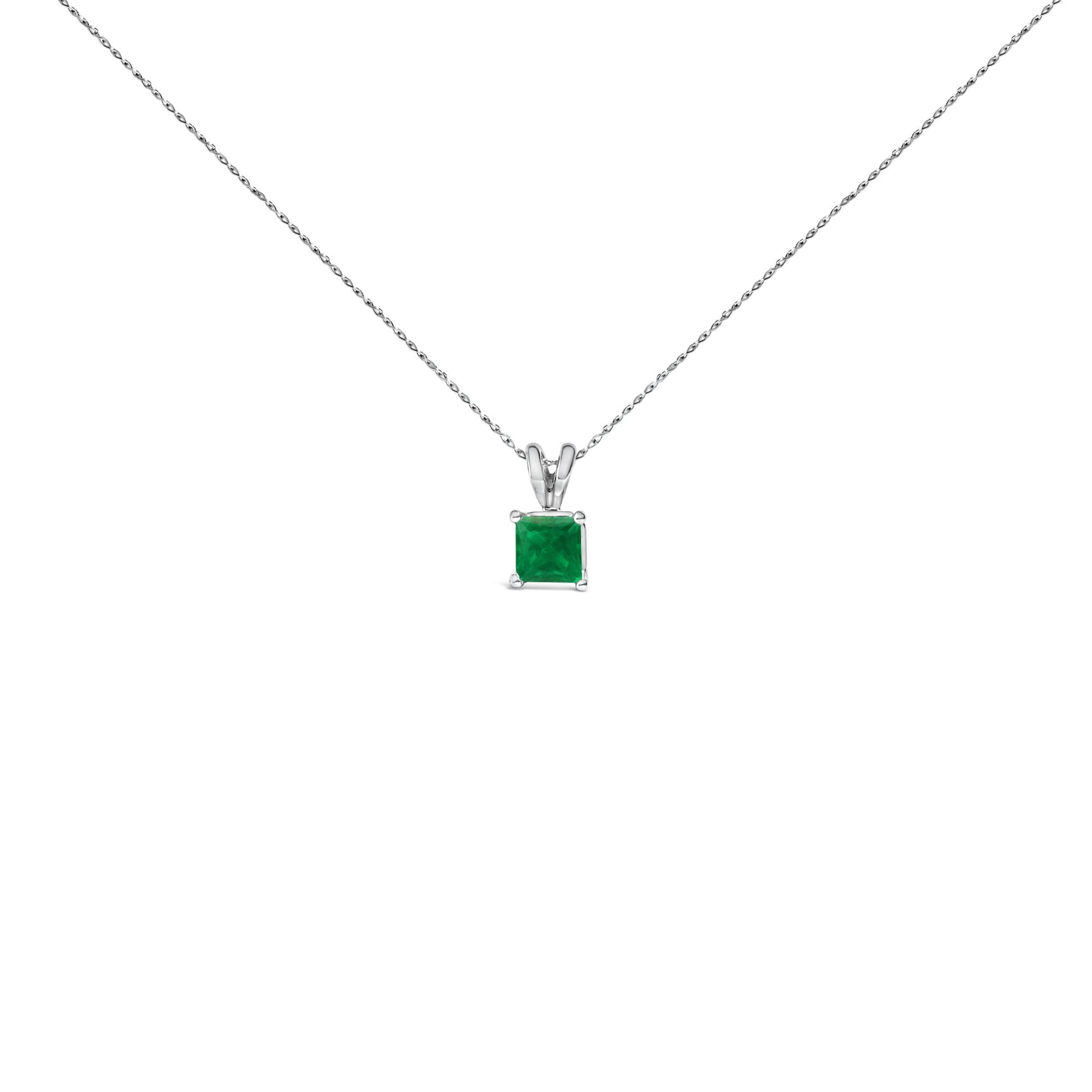 Front-facing shot of a white necklace with a square green gemstone pendant in a four-prong setting.