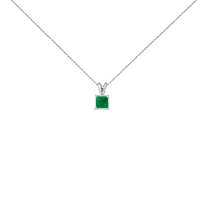 Front-facing shot of a white necklace with a square green gemstone pendant in a four-prong setting.
