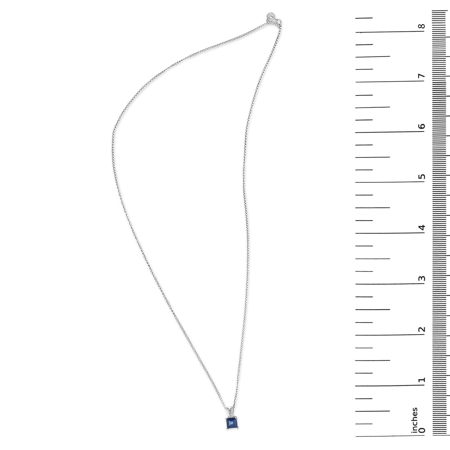 White necklace with a blue square-shaped gemstone pendant in a four-prong setting, shown flat with a measurement scale on the side, top-down angle.