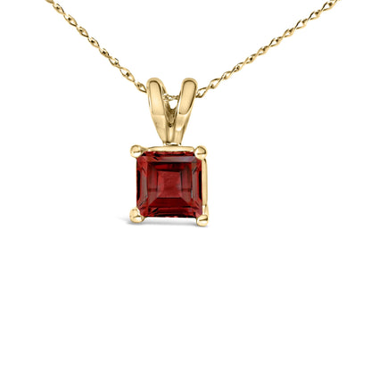 Close-up front view of a yellow metal necklace featuring a square-shaped red gemstone pendant held by four prongs.