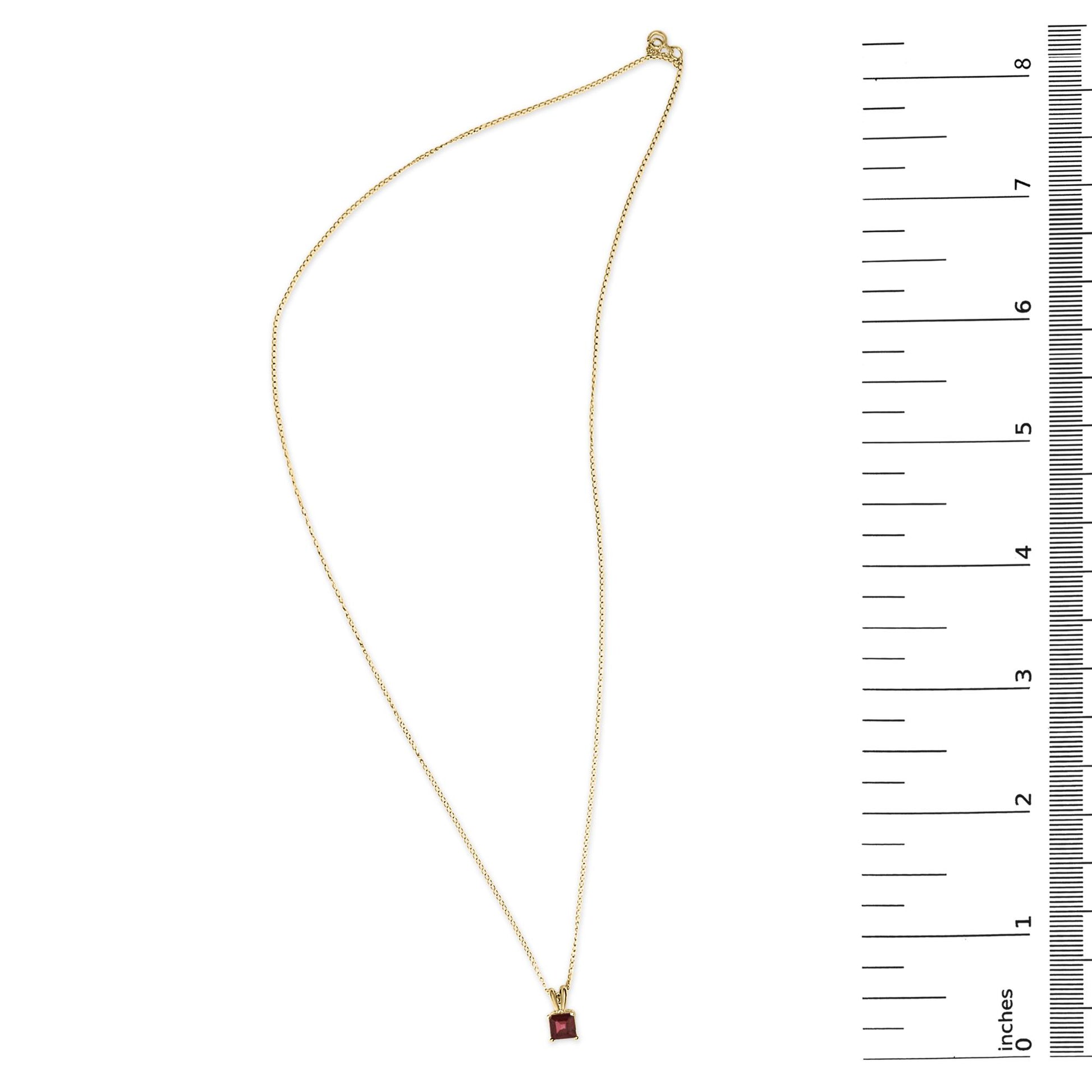 Yellow necklace with a square red gemstone pendant shown flat next to a ruler for scale, top-down angle.