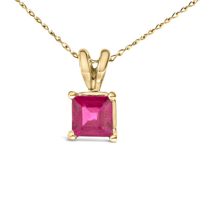 Yellow metal necklace with a princess-shaped red gemstone in a four-prong setting, shown in a front-facing close-up.