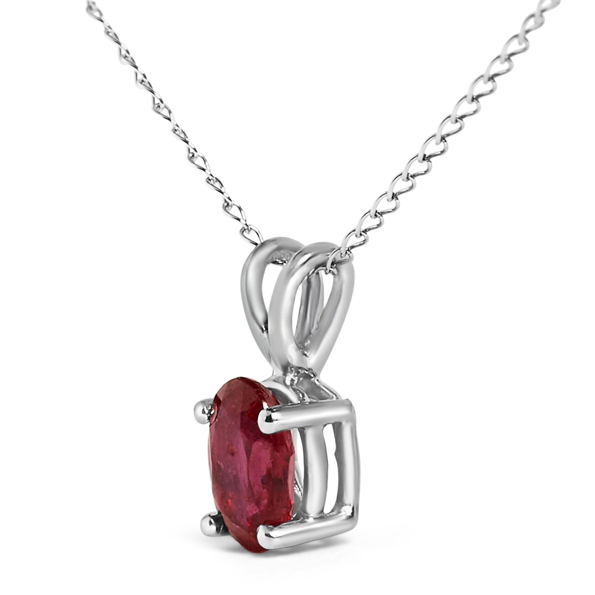 Close-up front angle of a white metal necklace pendant featuring an oval red gemstone in a four-prong setting on a fine chain.
