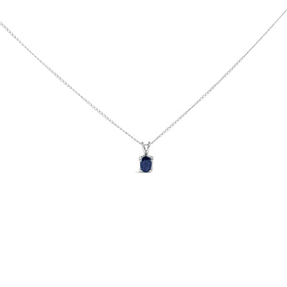Close-up front view of a white necklace with an oval blue gemstone pendant in a 4-prong setting on a chain.