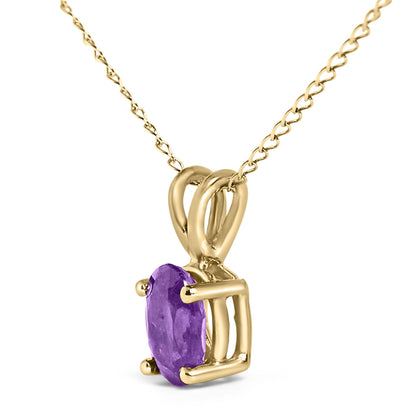 Close-up angled shot of a yellow metal necklace featuring a pendant with an oval purple gemstone in a four-prong setting.