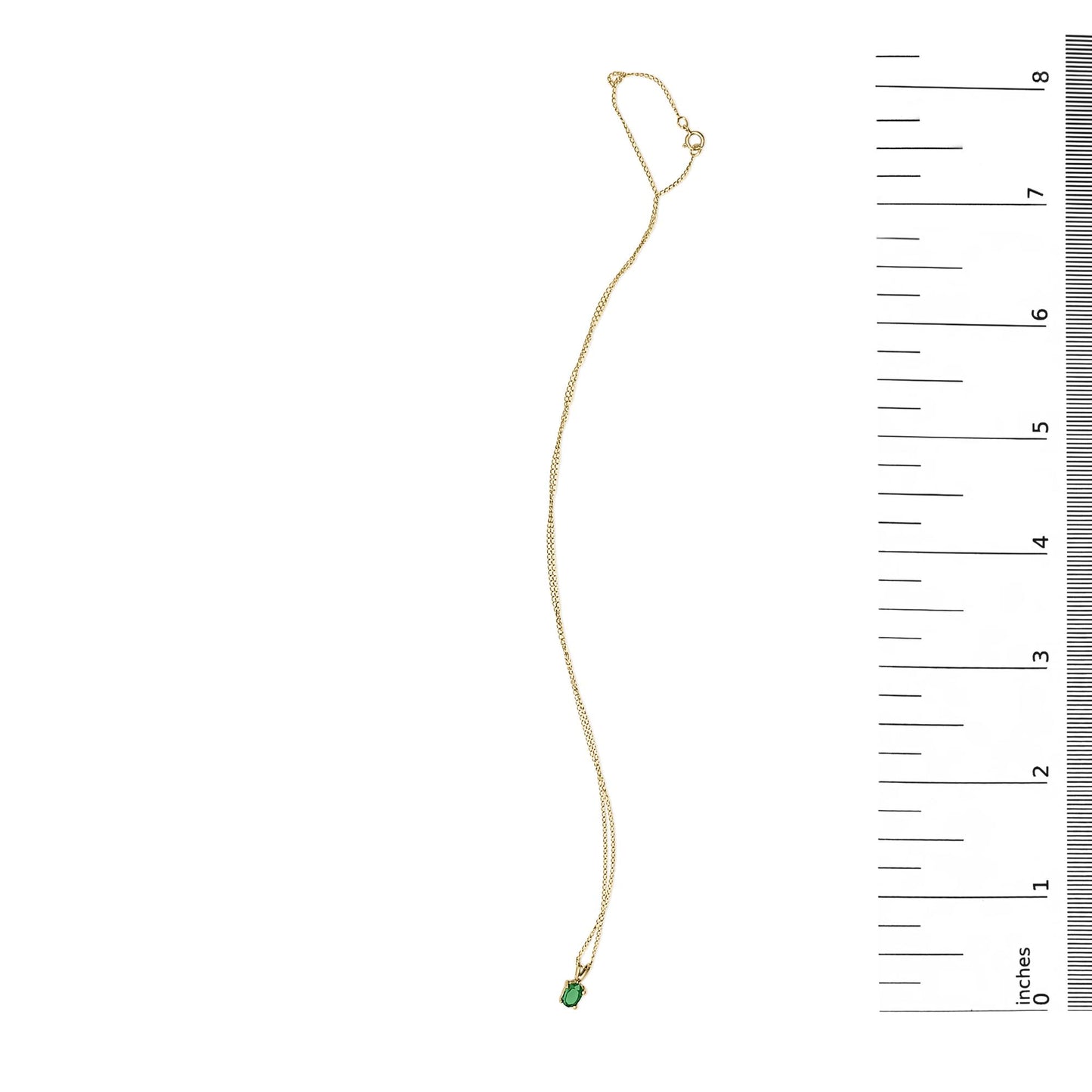 Yellow necklace with a small oval green gemstone pendant in a four-prong setting, shown flat on a white background with a ruler scale on the right side, top-down angle.