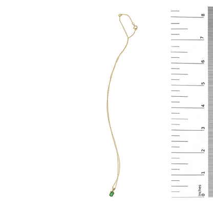 Yellow necklace with a small oval green gemstone pendant in a four-prong setting, shown flat on a white background with a ruler scale on the right side, top-down angle.
