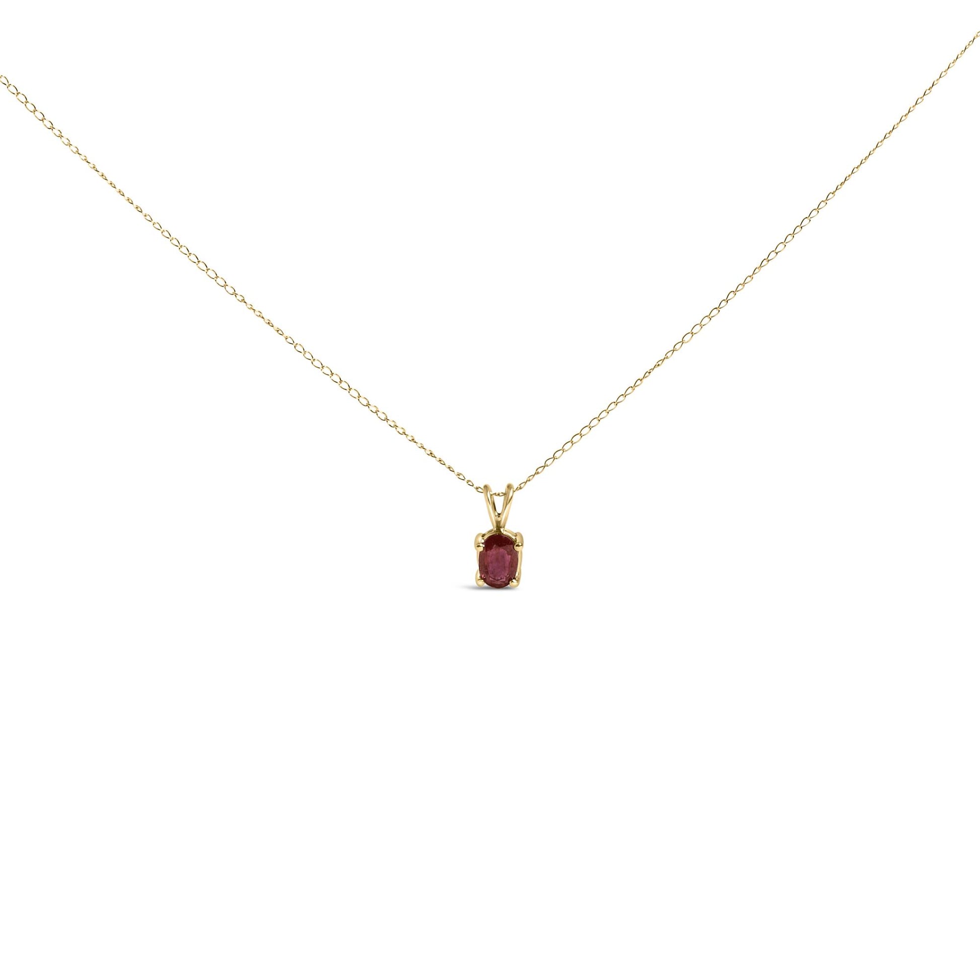 Yellow metal necklace with a small oval red gemstone in a four-prong setting, shown in a front-facing close-up shot.