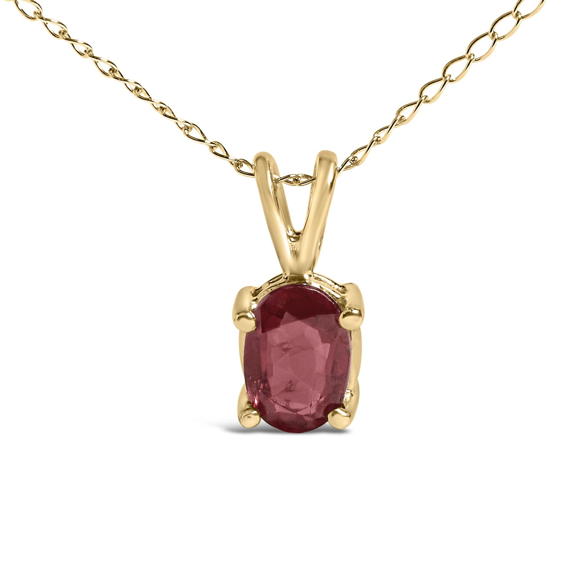 Close-up front view of a yellow metal necklace with a single oval red gemstone pendant in a four-prong setting.