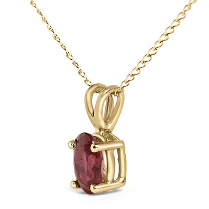Close-up side angle of a yellow necklace pendant featuring a single oval red gemstone in a four-prong setting on a twisted chain.