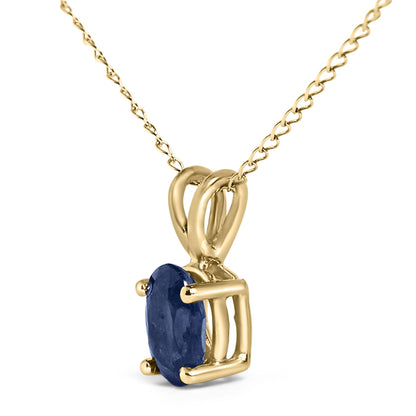 Close-up side angle of a yellow metal necklace featuring an oval-shaped blue gemstone in a four-prong setting.