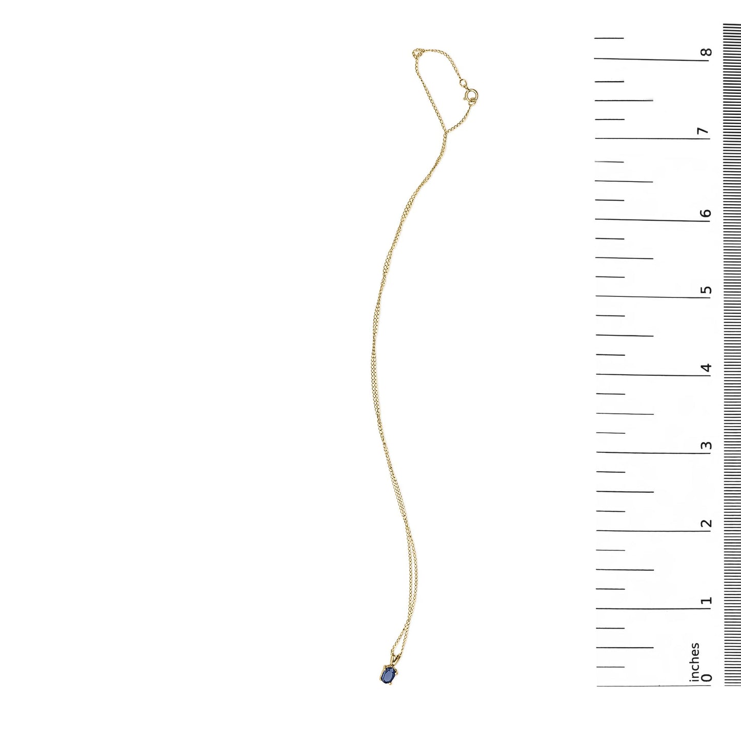 Yellow metal necklace with an oval blue gemstone in a four-prong setting, shown flat on a white background next to a ruler for scale, photographed from above.