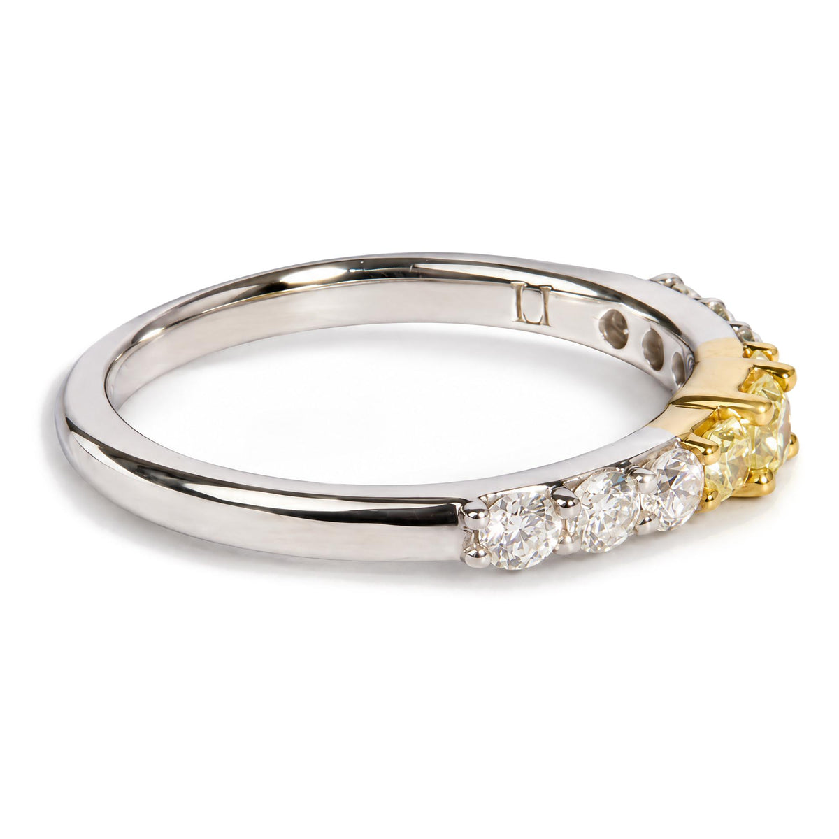 Close-up front angled view of a ring featuring a white metal band with prong-set round white gemstones and a yellow metal section with prong-set radiant yellow gemstones.