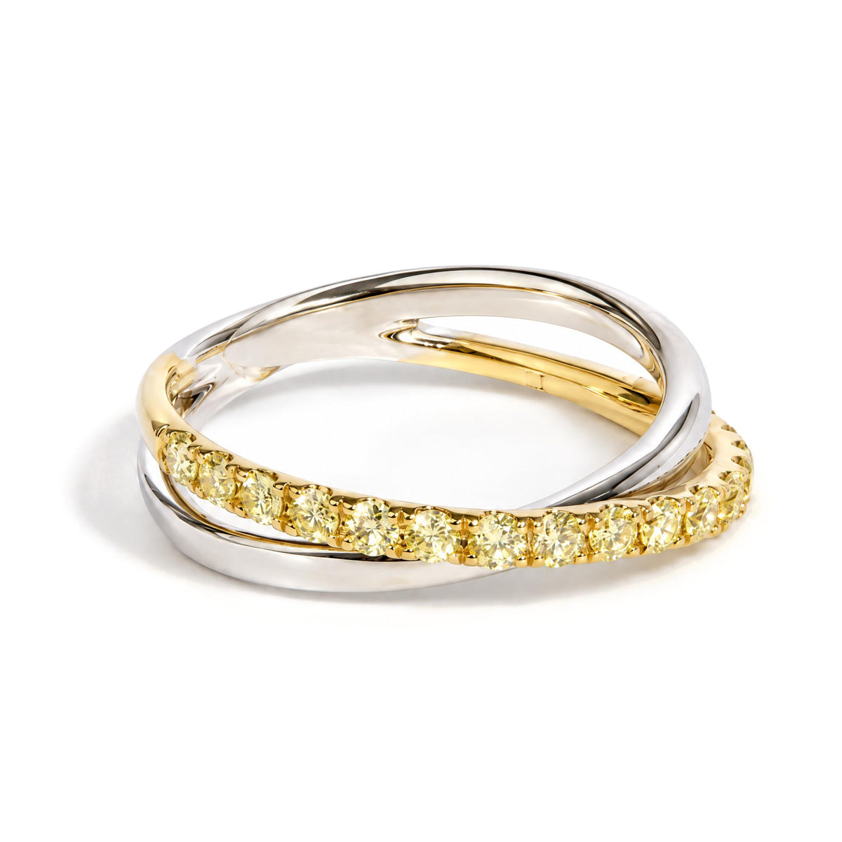 Close-up image of two intertwined rings, one in yellow metal with round yellow gemstones set in prongs, the other in white metal, shown on a white background.