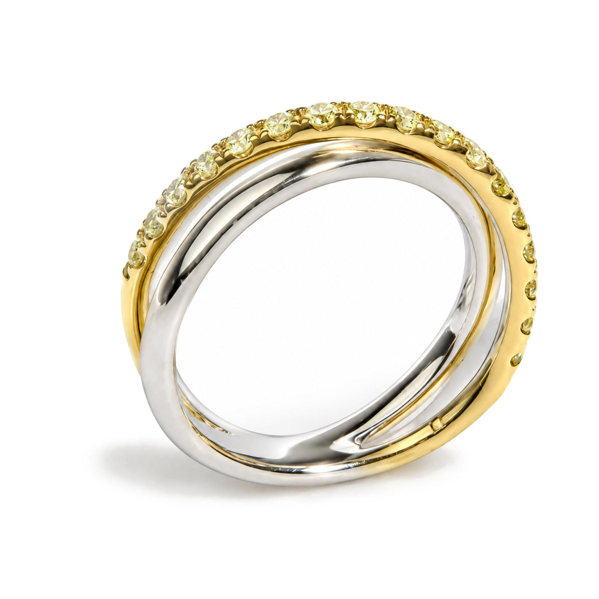 Close-up angle of two intertwined rings, one with a smooth white metal band and the other yellow metal band set with round prong-set yellow gemstones.