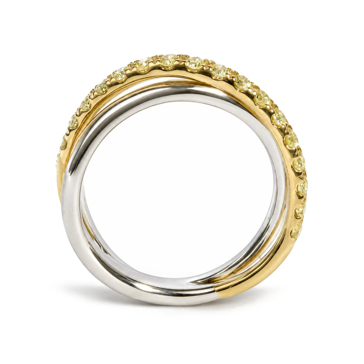 Close-up front angle of two intertwined rings, one yellow metal with prong-set round yellow gemstones encircling it and the other smooth white metal ring.
