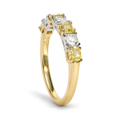 Close-up side angle of a ring with alternating cushion-shaped yellow and white gemstones in prong settings, featuring a yellow and white band.