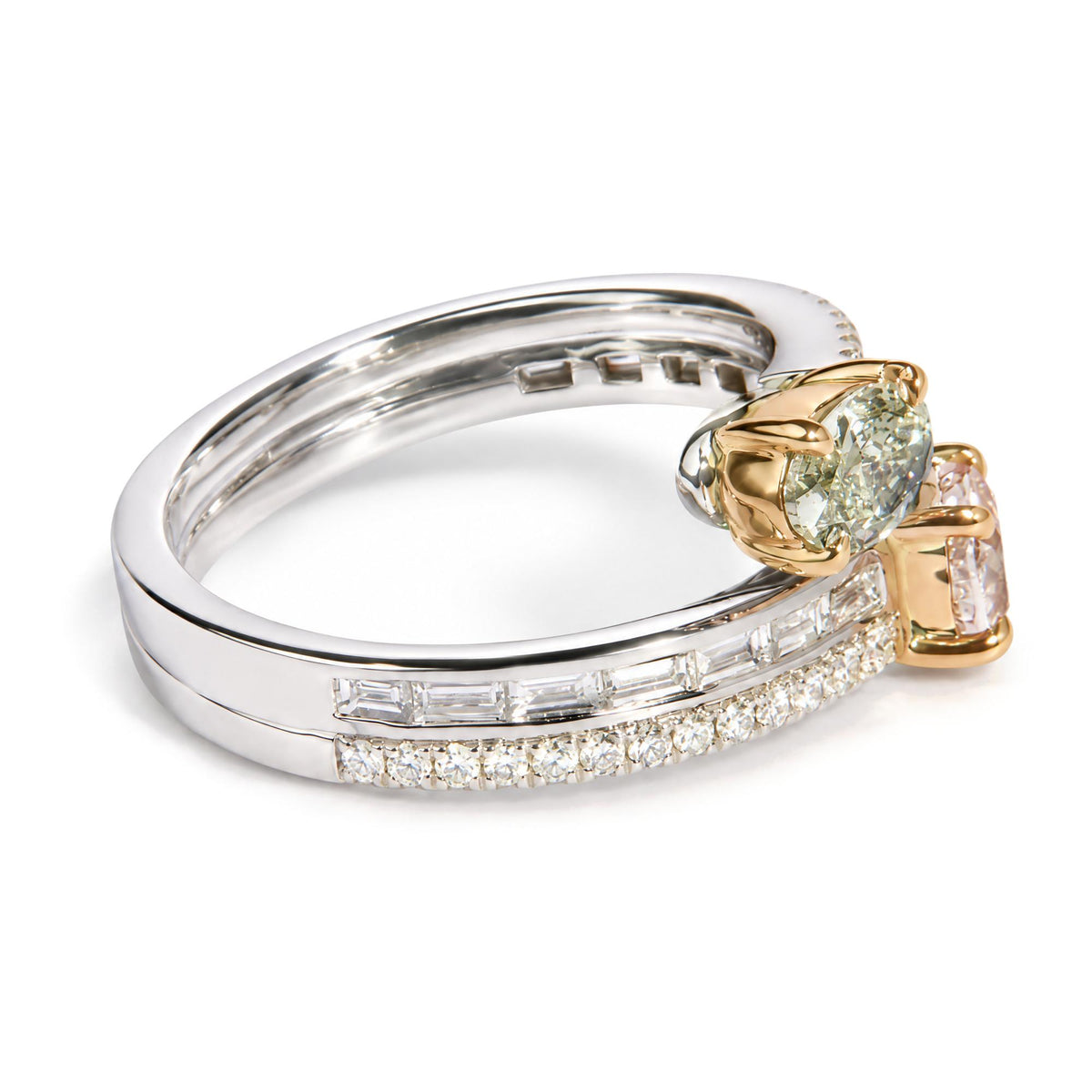 Close-up of a white and rose metal ring with a cushion-shaped light green gemstone set with rose metal prongs, flanked by a pink oval-shaped gemstone on one side and two bands featuring channel-set baguette and prong-set round white gemstones, shown from a diagonal angle.
