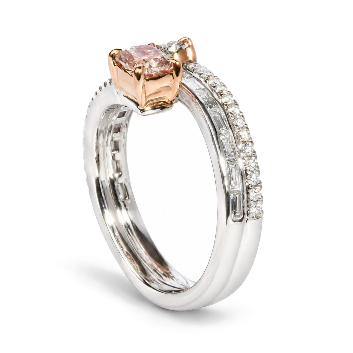 Close-up angled view of a white and rose metal ring with a cushion-shaped pink gemstone in prong setting, an oval-shaped green gemstone in prong setting, baguette-shaped white gemstones in channel setting, and round-shaped white gemstones in prong setting.