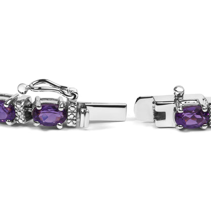 Close-up side view of a white metal bracelet clasp featuring oval purple gemstones and small round white gemstones in a shared prong setting.