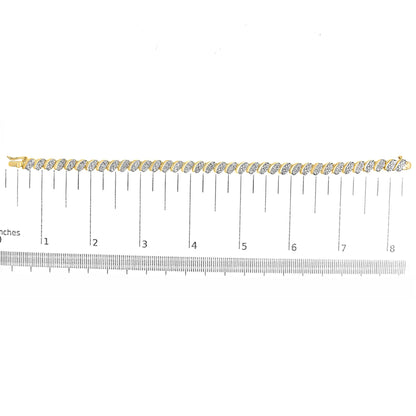 Yellow metal bracelet with alternating links featuring white round gemstones in a pave setting, shown flat on a ruler for size reference, top-down angle.