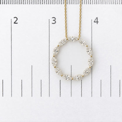 Close-up front view of a yellow metal necklace with an oval-shaped pendant made of marquise-shaped white gemstones in a shared prong setting, shown on a scale.