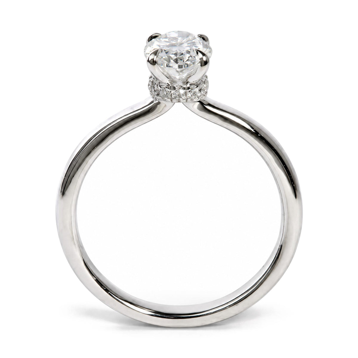 Close-up front angle of a white ring featuring a large oval white gemstone in a 4-prong setting, surrounded by smaller round white gemstones in prong settings along the band.