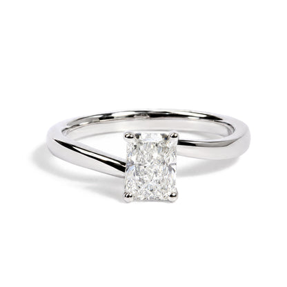 Close-up front angle of a white metal ring with a single radiant-shaped white gemstone in a prong setting.