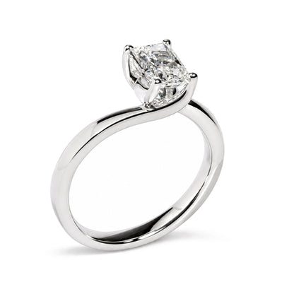 Close-up side angle of a white metal ring with a single radiant-shaped white gemstone in a prong setting.