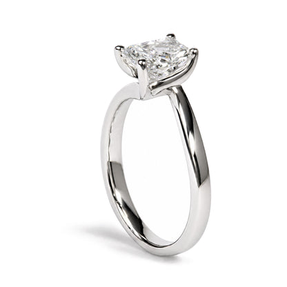 Close-up side angle of a white metal ring featuring one radiant-shaped white gemstone in a prong setting, shown on a white background.