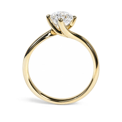Close-up front angle of a yellow metal ring with a round white gemstone in a prong setting.