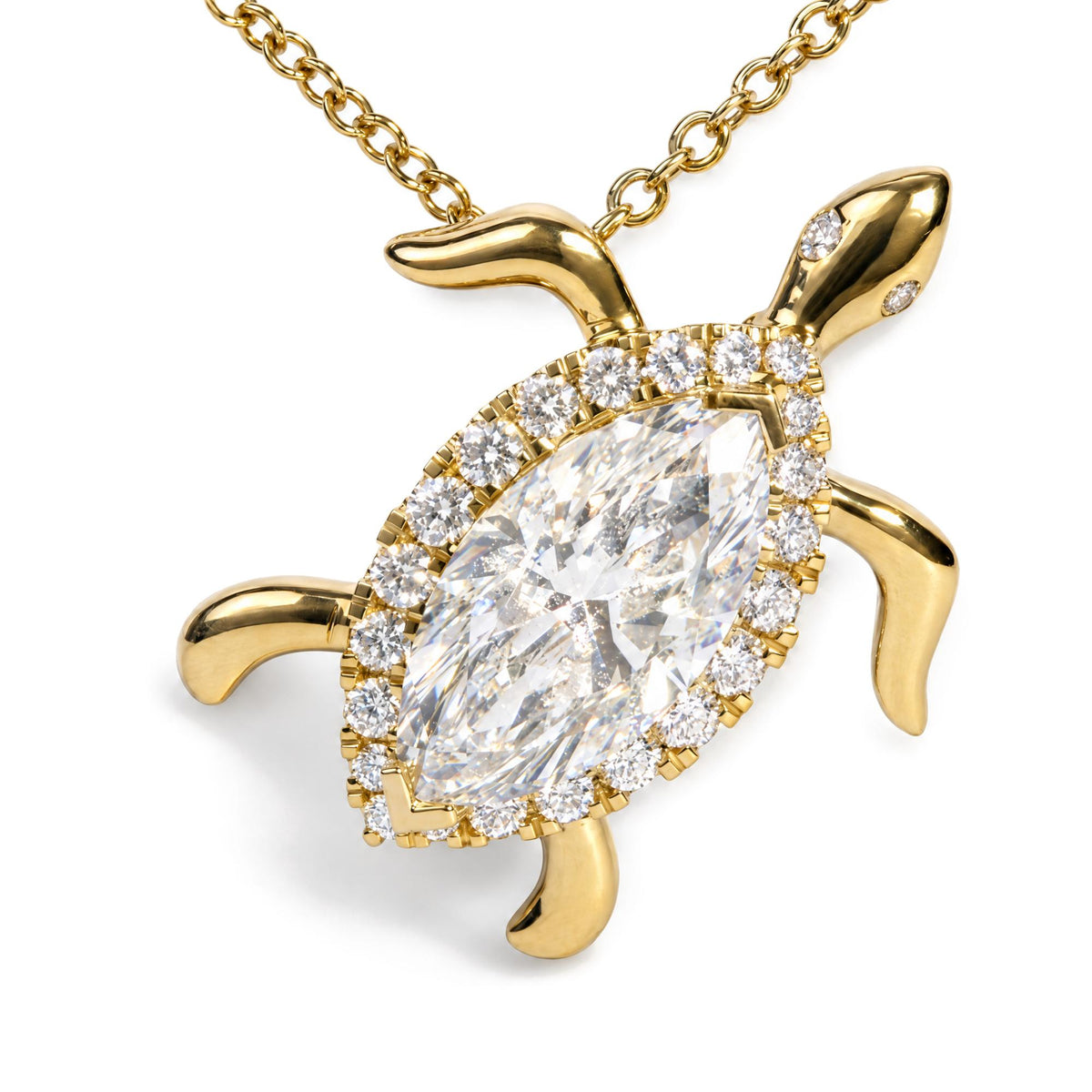 Close-up front angle of a yellow metal turtle-shaped necklace pendant featuring a large marquise-shaped white gemstone in the center surrounded by round white gemstones, shown on a white background.