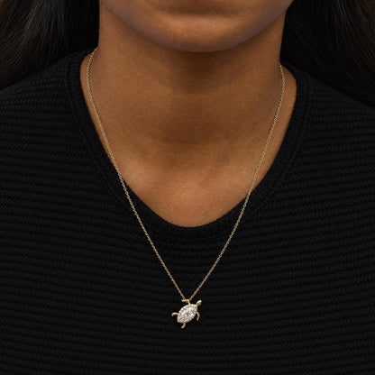 Close-up front view of a model wearing a yellow necklace featuring a turtle-shaped pendant with a marquise white gemstone center surrounded by round white gemstones.